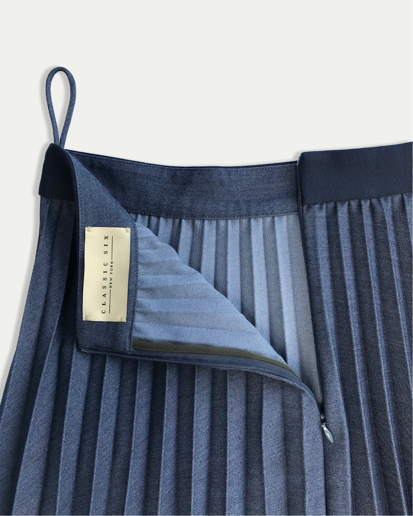 Blue pleated skirt with a brand label on a white background