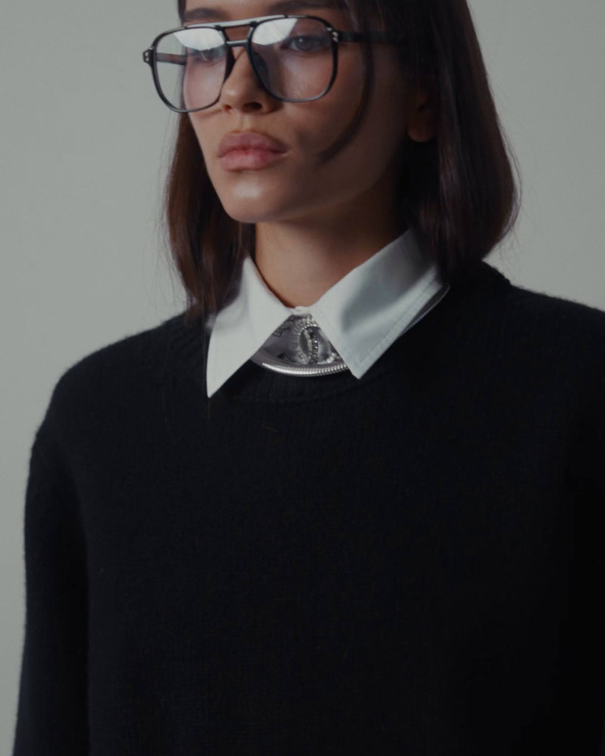a woman in a black sweater and glasses