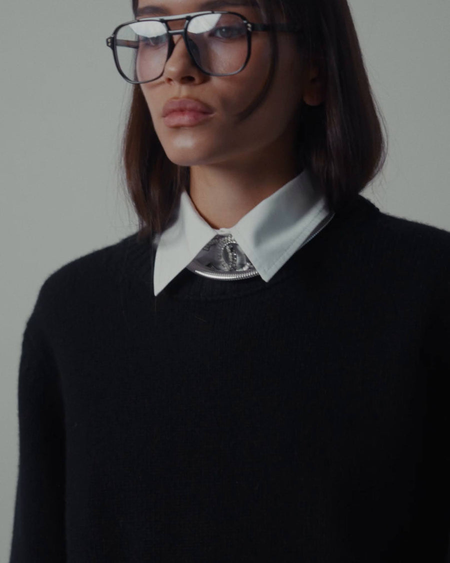 a woman in a black sweater and glasses
